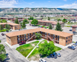 Expansive aerial shot of the Rock Springs Apartments, located in Wyoming, with a focus on the surrounding commercial area and the ongoing renovation of the affordable housing complex.